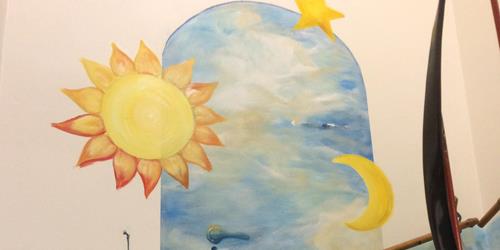 Billede af et af vores vægmalerier med sol, måne og stjerne